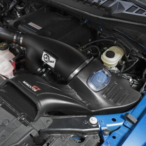 Close-up of an installed intercooler system in the engine compartment of a US vehicle, black housing with visible branding.